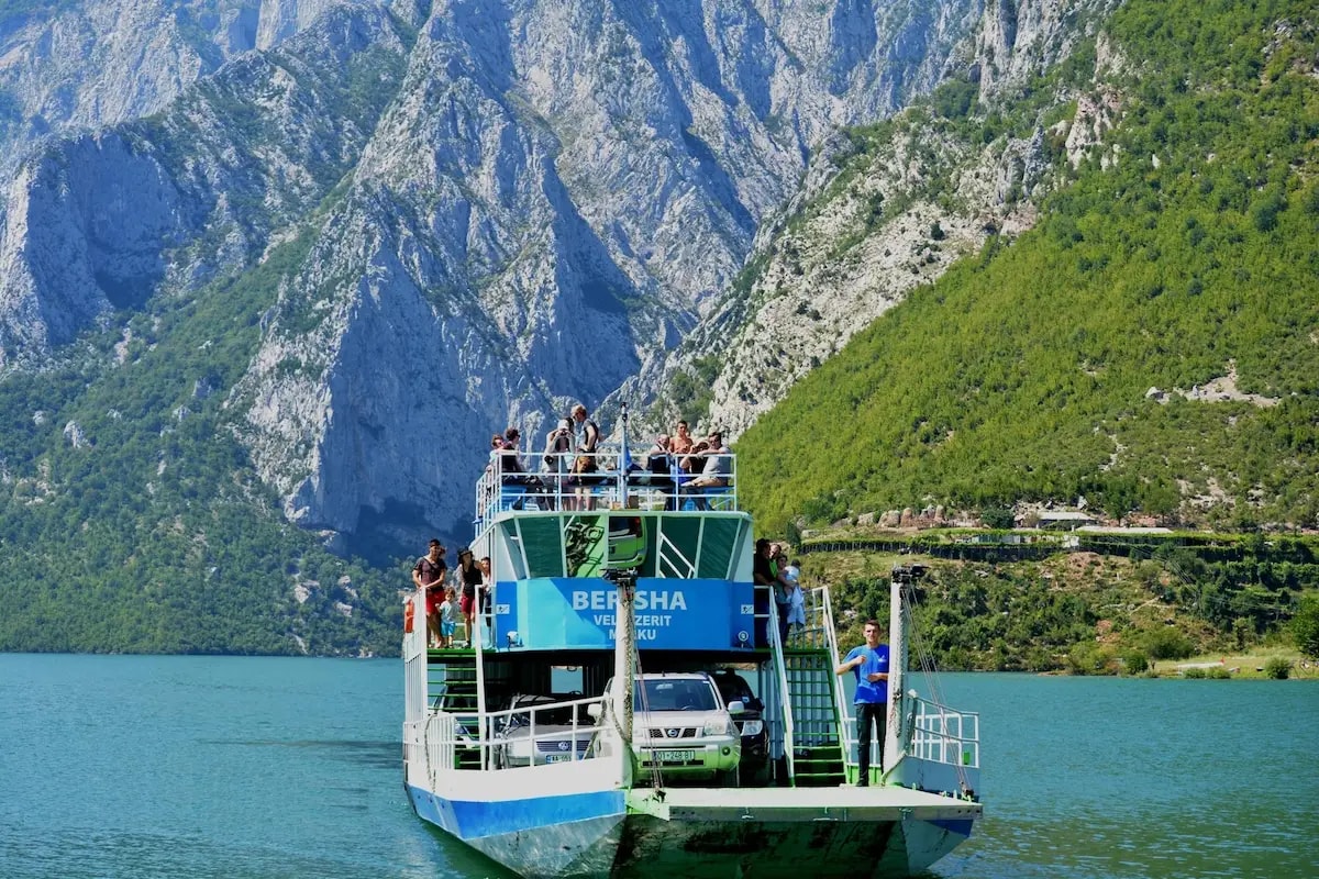 The ferry crossing Lake Koman in Albania with steep mountain cliffs rising from the water